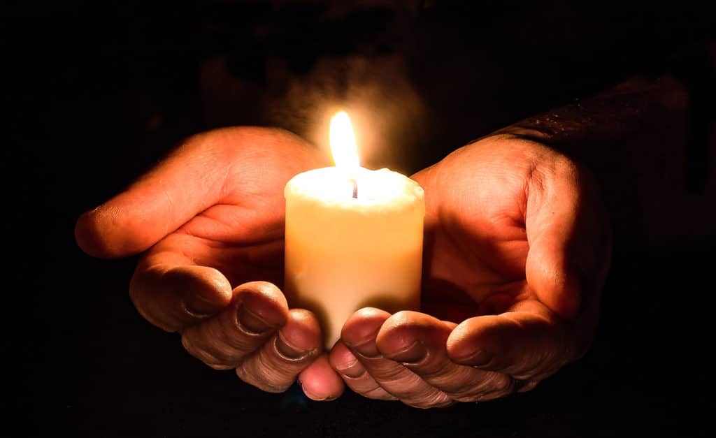 Halte spirituelle - Lumignon dans des mains en offrande